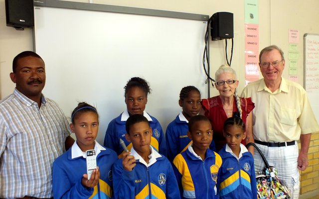 Agter vlnr is Tommy Volkwyn (skoolhoof), Anita en Jack Doyle saam met leerders voor die Interaktiewe Witborde